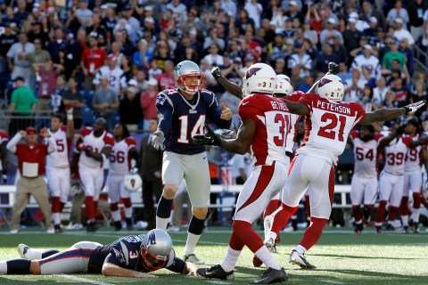 New England Patriots kicker Gostkowski lays on the ground after missing a field goal as punter Mesko reacts while Arizona Cardinals players celebrate their win during the final second of the fourth quarter of their NFL football game in Foxborough