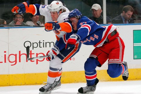 image: PA Parenteau of the New York Islanders is covered by Milan Jurcina of the New York Rangers in the first period of an NHL hockey game at Madison Square Garden in New York City, on Dec. 26, 2011.
