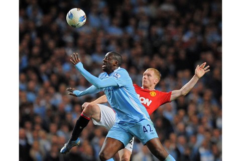 Manchester City's Ivory Coast footballer Yaya Toure (Foreground) vies for the ball against Manchester United's English midfielder Paul Scholes