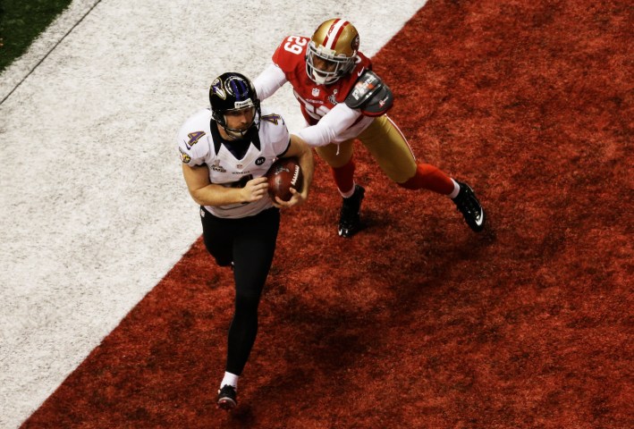 Punter Sam Koch of the Baltimore Ravens holds the ball in the endzone as he takes a safety in the final minute of the fourth quarter against Chris Culliver of the San Francisco 49ers during Super Bowl XLVII at the Mercedes-Benz Superdome in New Orleans, Feb. 3, 2013.