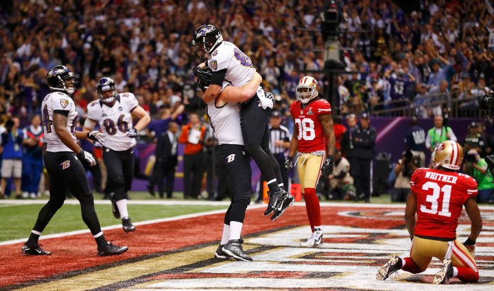 Baltimore Ravens tight end Dennis Pitta is lifted in celebration by teammate Matt Birk after his touchdown against the San Francisco 49ers during the second quarter in the NFL Super Bowl XLVII football game in New Orleans, Feb. 3, 2013.