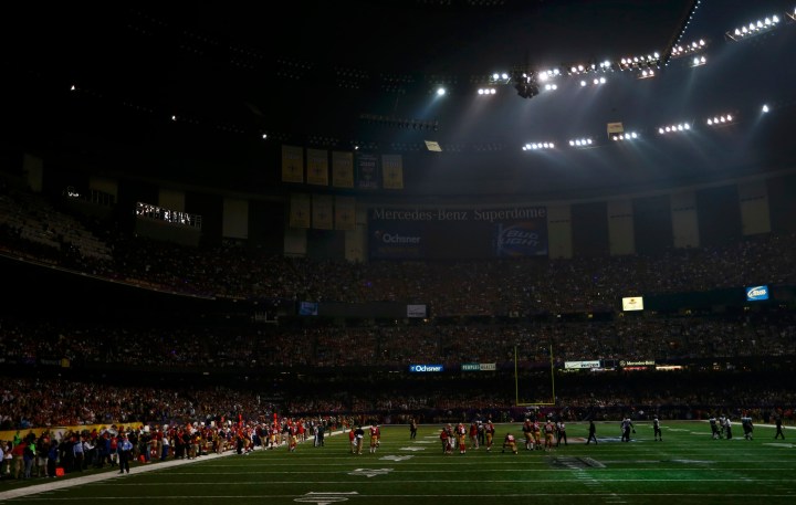 Players mill around the field after half of the lights went out during the third quarter of the NFL Super Bowl XLVII football game between the Baltimore Ravens and the San Francisco 49ers in New Orleans, Feb. 3, 2013.  