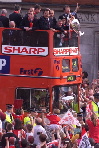 Manchester United manager Alex Ferguson holds the European Cup trophy as his team participates in a parade near Manchester after winning an historic treble, including the FA Cup, the premier league trophy and the European Cup, in one season, on May 27, 1999.