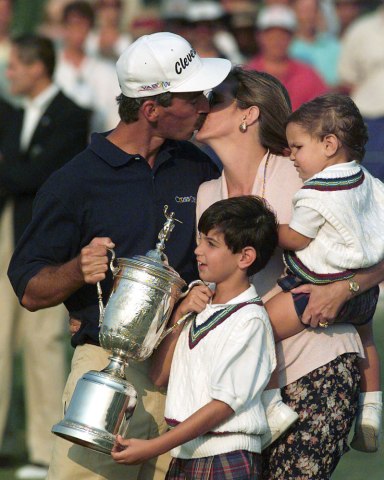 Corey Pavin leans to kiss his wife Shannon as his children Ryan, 9, and Austin, 2, take in the ceremonies after the final round of the U.S. Open at the Shinnecock Hills Golf Club in Southampton, N.Y., June 18, 1995.