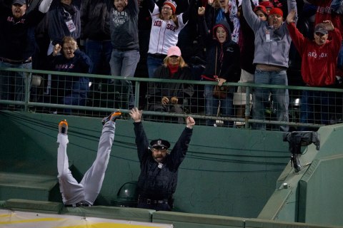 Detroit's Torii Hunter falls into the bullpen trying to catch Red Sox designated hitter David Ortiz's home run that tied the game in the eighth inning of game two of the American League Championship Series at Fenway Park in Boston, Oct. 13, 2013.