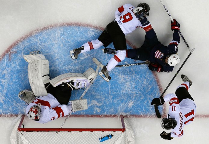 The puck sits in the net behind Switzerland's goalie Schelling after a goal by Team USA's Kessel during the first period of their women's preliminary round hockey game at the Sochi 2014 Winter Olympic Games