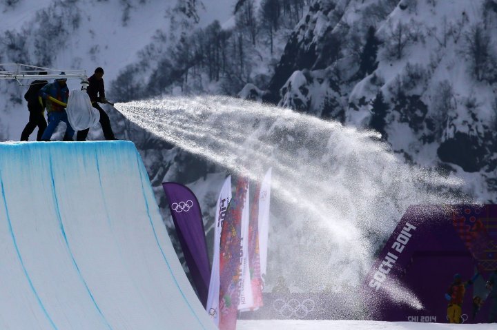 Workers spray down the halfpipe before competition begins in the Snowboard Men's Halfpipe Qualification Heats Feb. 11, 2014 in Sochi, Russia. 