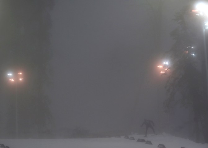 A skier travels amid heavy fog at the Laura Cross Country Ski and Biathlon Center.