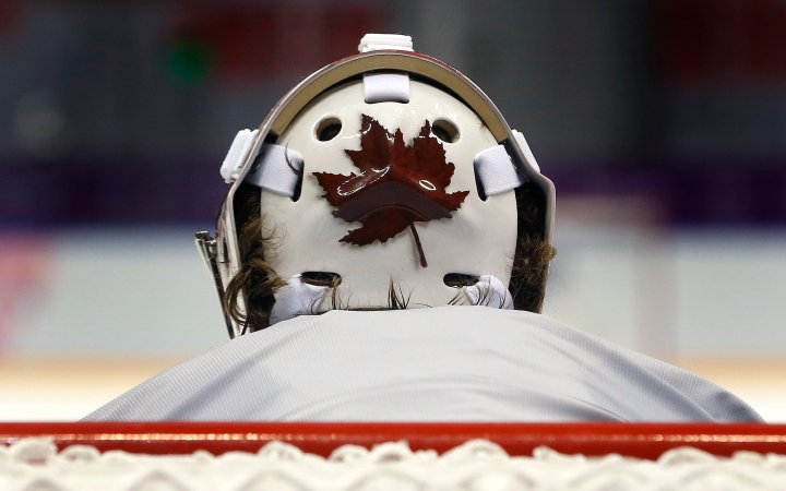 Canada goaltender wears a helmet decorated with a Canadian maple leaf during a training session.